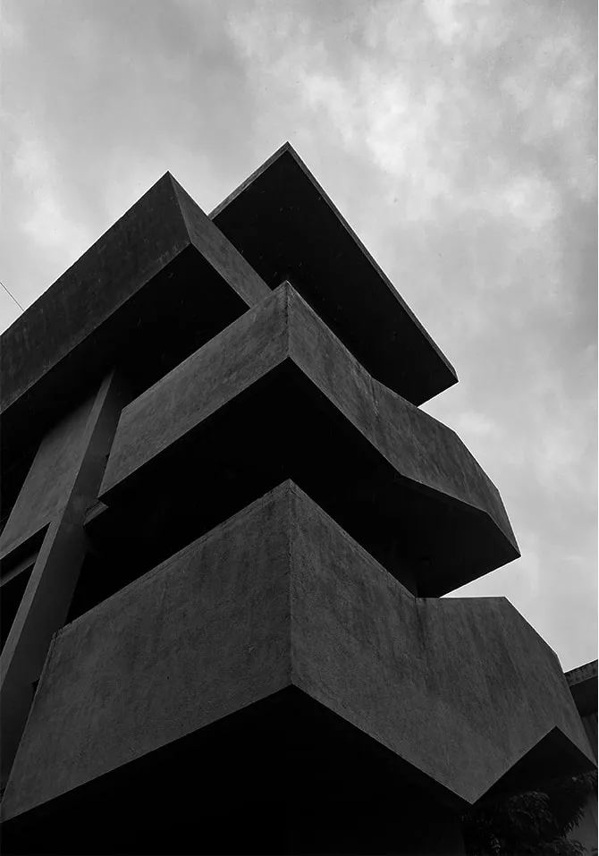 Black-and-white photograph looking up at stacked cantilevered concrete floors.