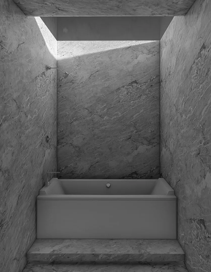 Skylit marble bathroom with a freestanding tub.