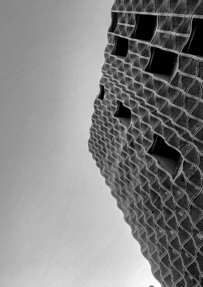 Black-and-white photograph of a tower with an undulating sculpted facade.